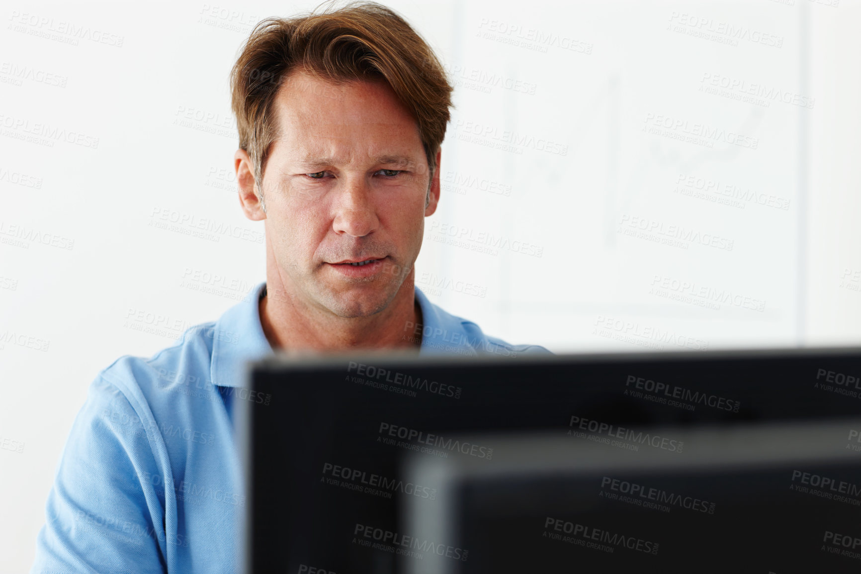 Buy stock photo Shot of a mature man concentrating on his computer screen