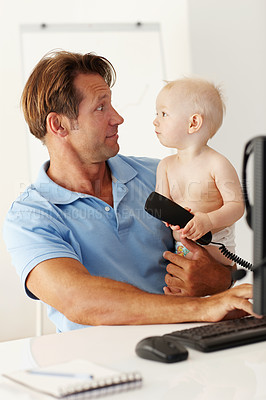 Buy stock photo Father, baby and computer for remote work in home with desktop, communication and multitasking. Man, young male child and online job with telephone call in house for funny, connectivity and work