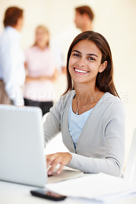 Buy stock photo Shot of an attractive young woman using a laptop in a brightly lit office