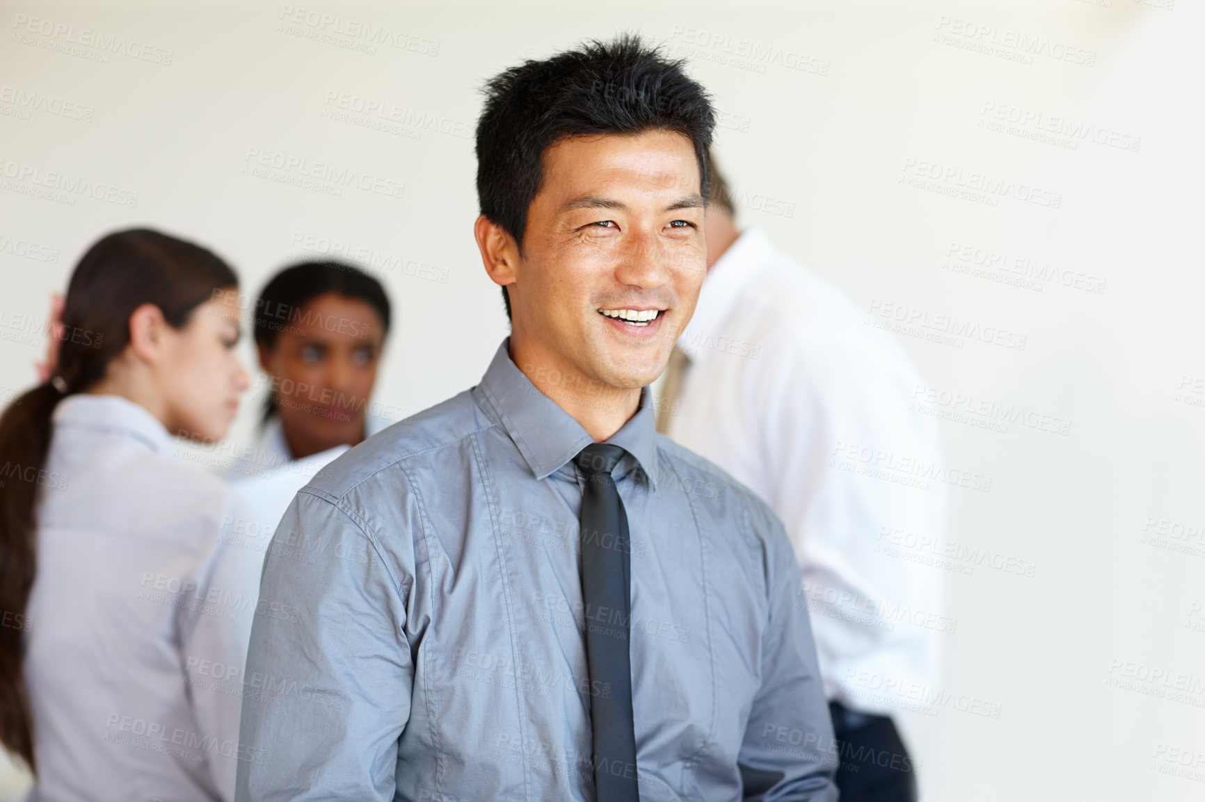 Buy stock photo Businessman, smile and thinking in office with team building and professionals at workplace. Asian, male person and employees with cheerful, happy and future for business, company and startup