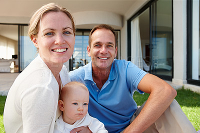 Buy stock photo Outdoor portrait of a happy family relaxing on the grass