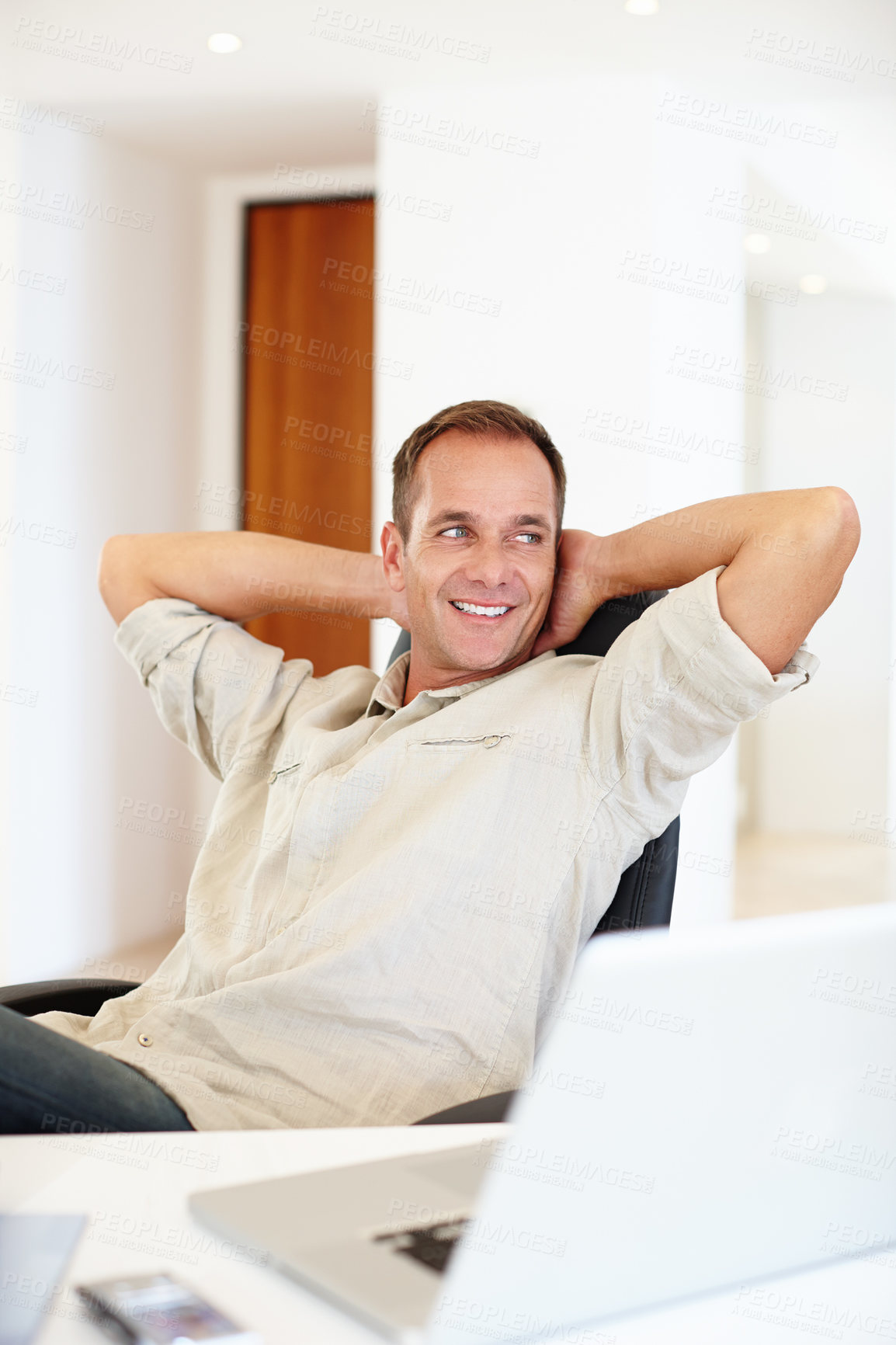 Buy stock photo Cropped shot of a handsome man relaxing in his office space