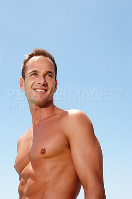 Buy stock photo Cropped shot of a muscular handsome man standing topless outdoors