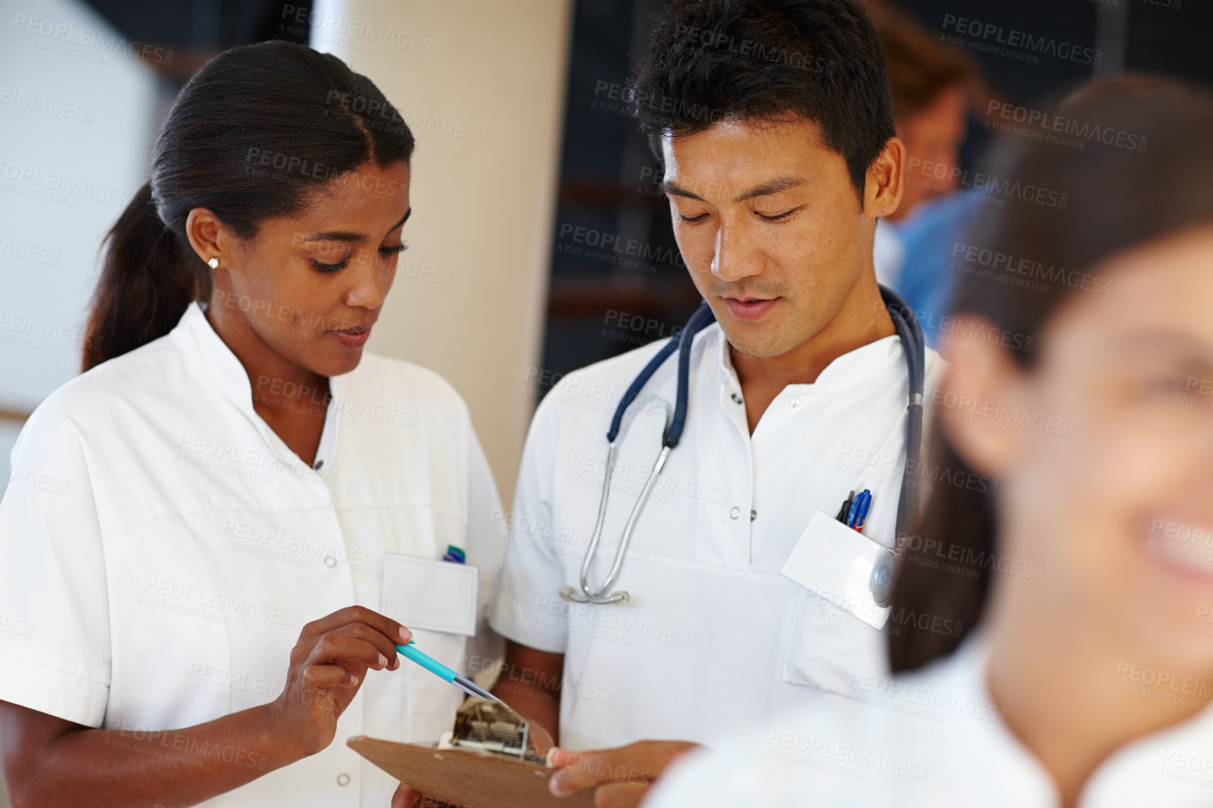 Buy stock photo Shot of two medical professionals discussing a document