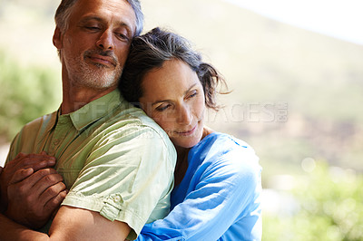 Buy stock photo A cropped shot of an affectionate mid adult couple holding each other outdoors