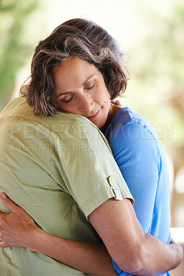 Buy stock photo A cropped shot of an affectionate couple embracing outdoors