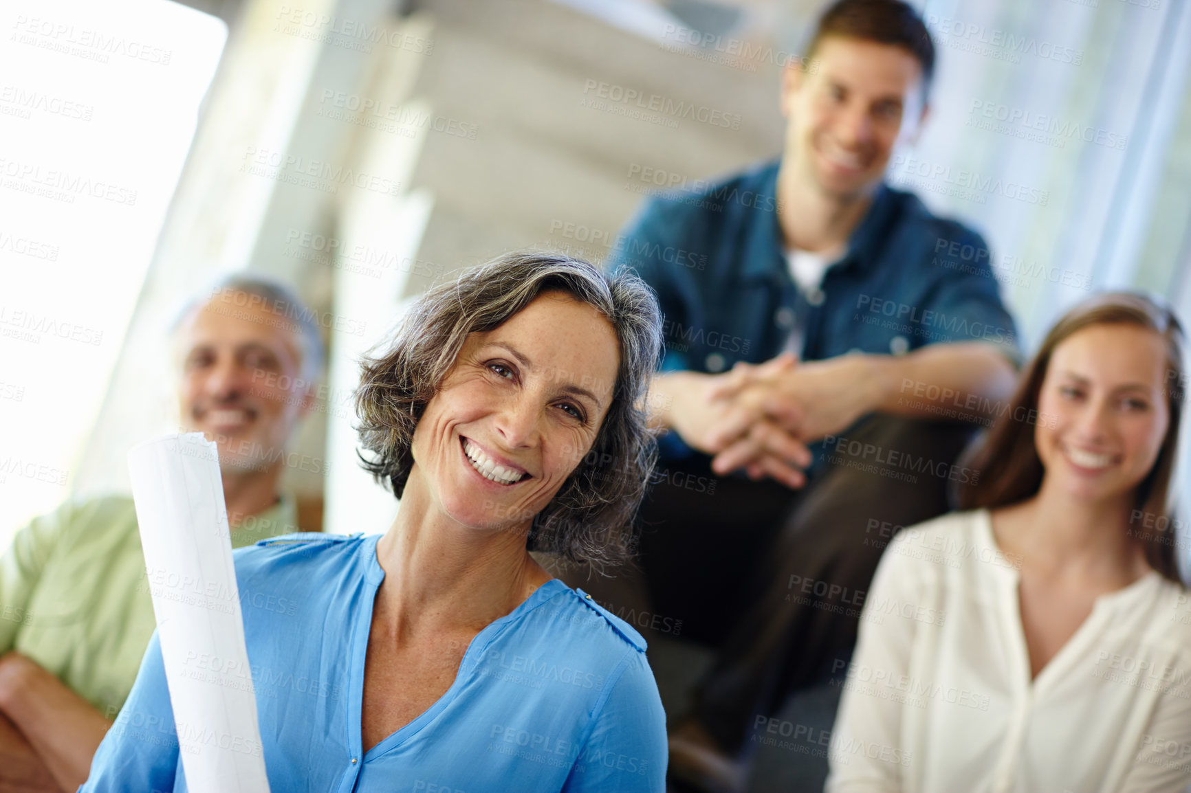 Buy stock photo A cropped portrait of a happy mid adult woman holding a building plan and standing in her home with her family