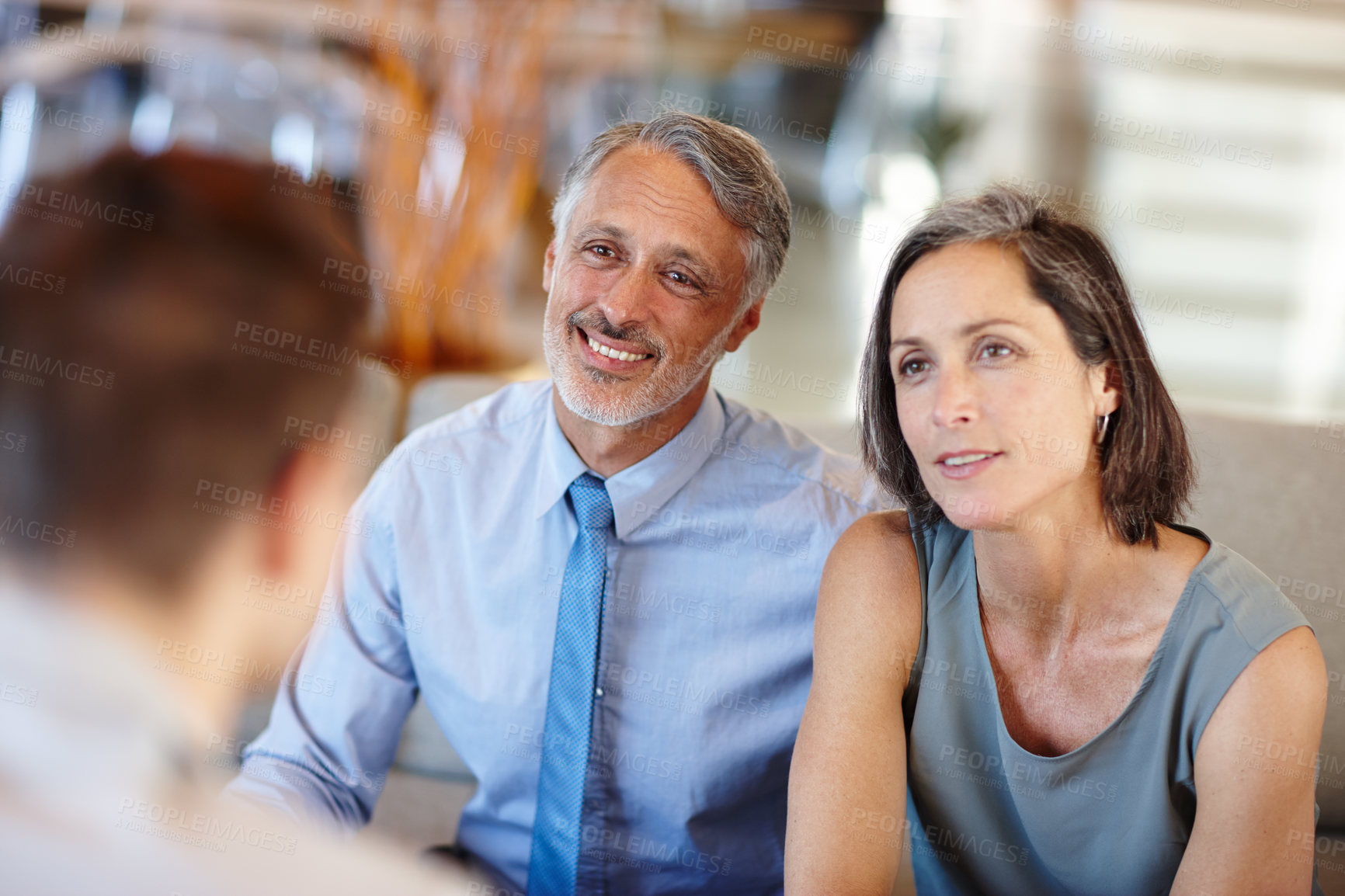 Buy stock photo A cropped shot of a mid adult couple having a meeting with a young businessman