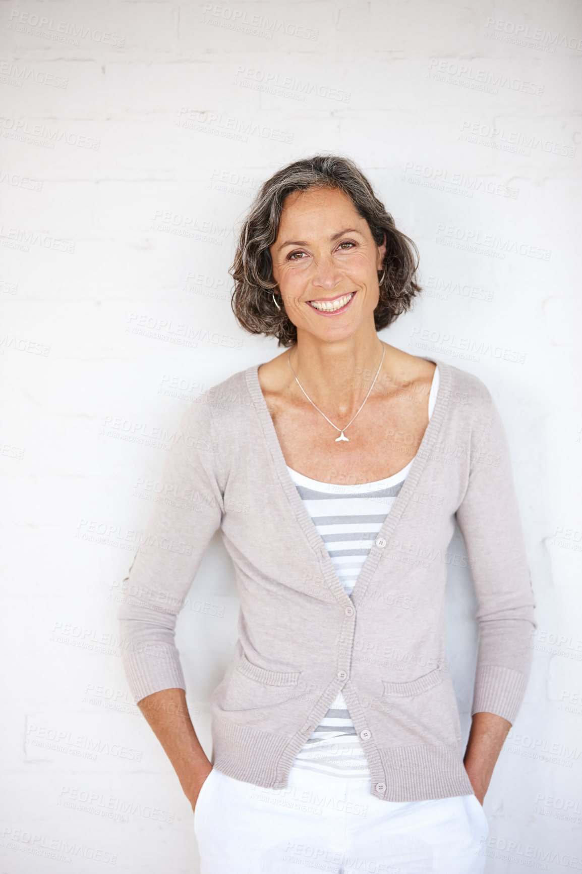 Buy stock photo A mature woman smiling happily while posing in a studio