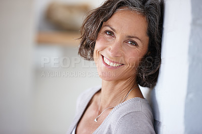 Buy stock photo Shot of an attractive mature woman leaning against a wall