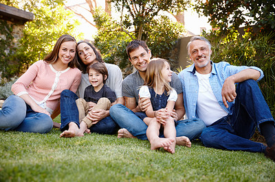 Buy stock photo A portrait of a multi-generational family sitting together in their garden