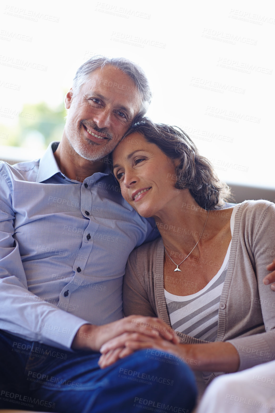 Buy stock photo Mature couple, smile and hug in home for portrait with bonding, care and together with love in living room. Senior people, man and woman with embrace, marriage and holding hands on couch in lounge