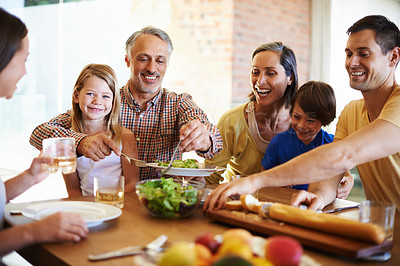 Buy stock photo Shot of a happy family enjoying dinner together at the dining table