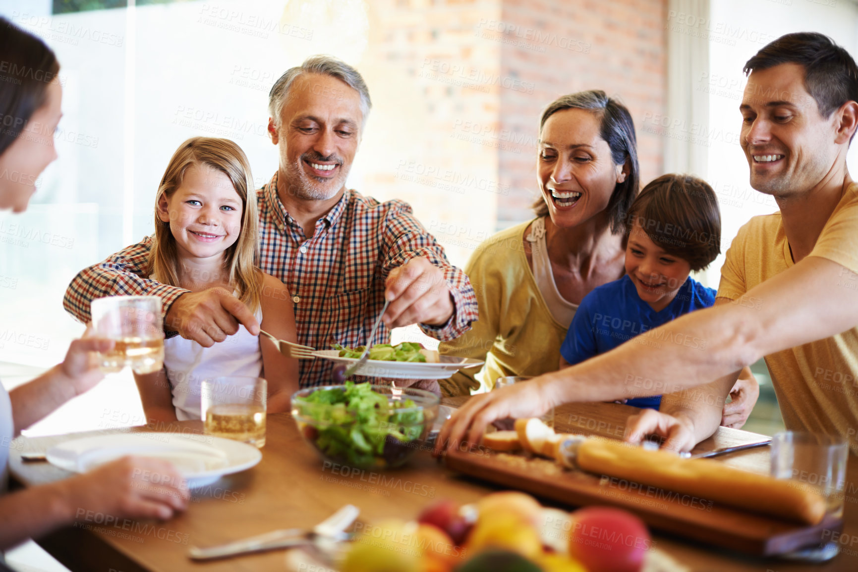 Buy stock photo Shot of a happy family enjoying dinner together at the dining table