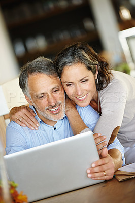 Buy stock photo Shot of a happy mature couple looking at a laptop together