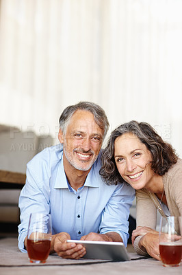 Buy stock photo Senior couple, home and portrait with tablet, smile and bonding together with internet and social media. Apartment, old man and mature woman on the floor, technology or watching series with drink