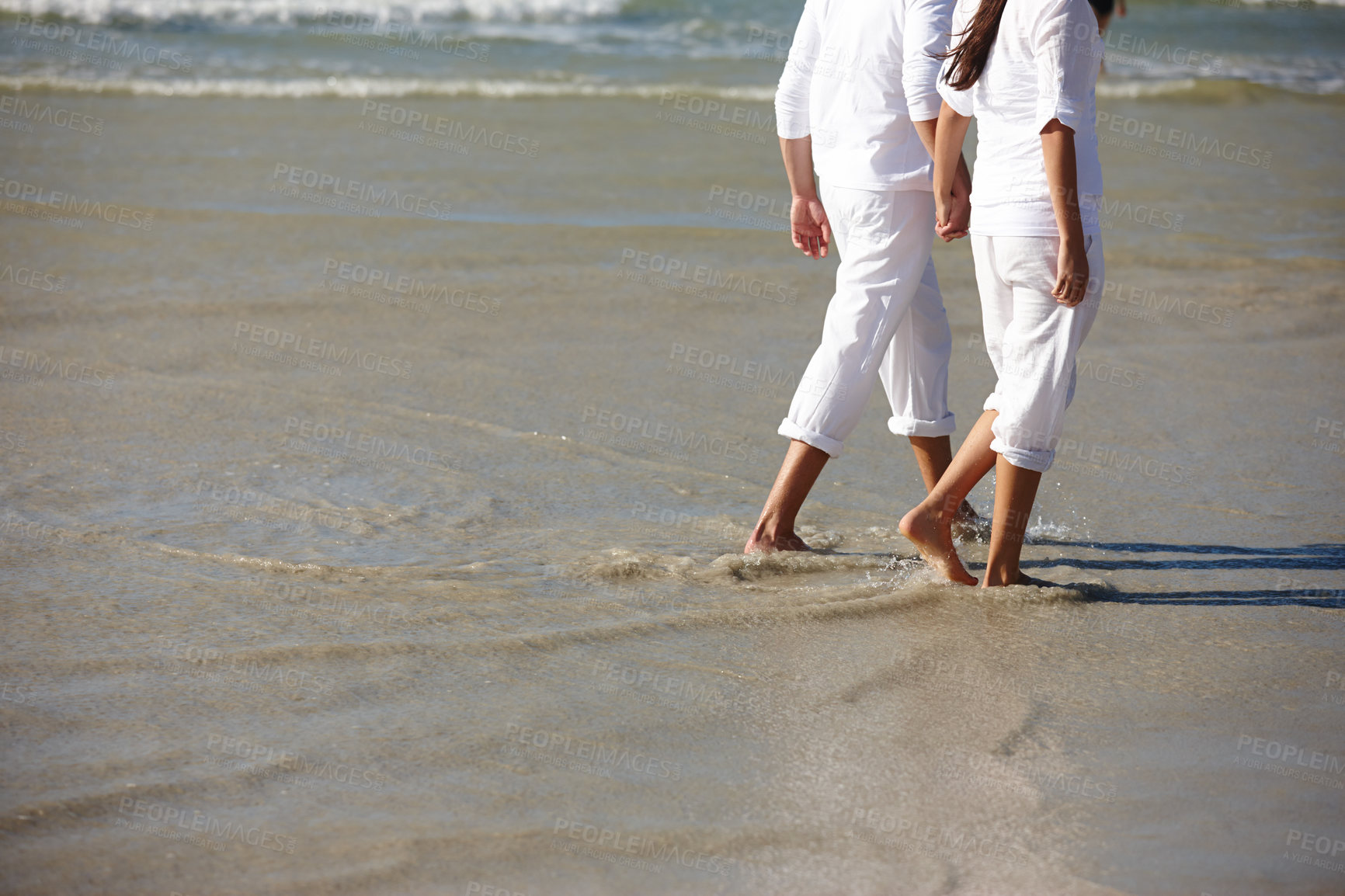 Buy stock photo Walking, beach and legs of couple in waves for summer holiday, vacation and weekend by ocean. Travel, sunset and feet of man and woman holding hands in water for bonding, relax and relationship