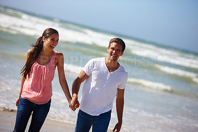 Buy stock photo Happy couple, beach and holding hands with love for bonding, embrace or outdoor holiday in nature. Young man and woman enjoying weekend, relationship or walk together on ocean coast for fun summer