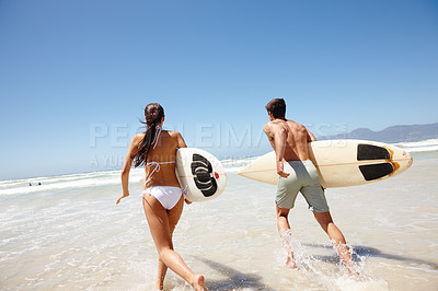 Buy stock photo Couple, water and surfboard for surfing or running with tide check, adventure and fitness with blue sky. Man, woman and surfer by beach in the morning for holiday, vacation and freedom with rear view