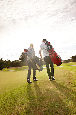 Buy stock photo Rear view shot of two friends out on the golf course together
