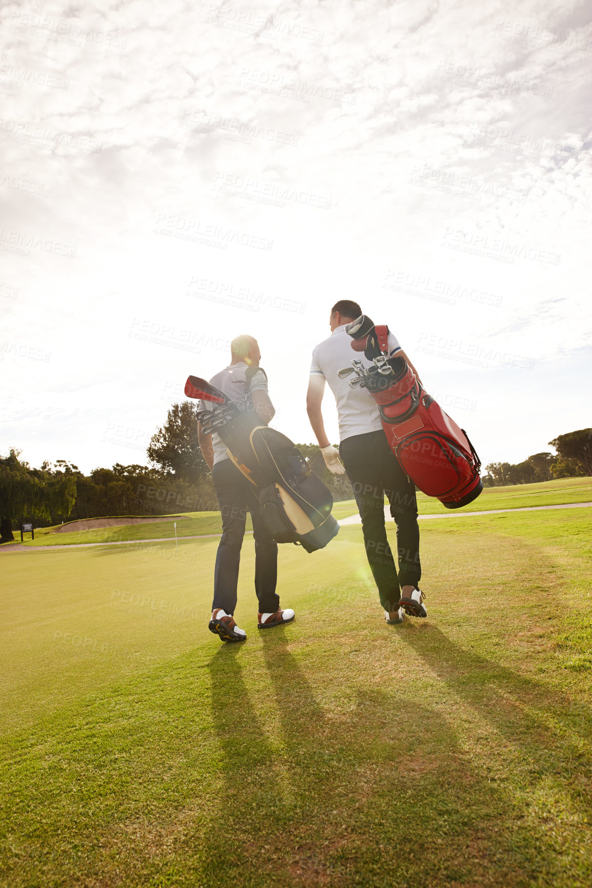 Buy stock photo Rear view shot of two friends out on the golf course together