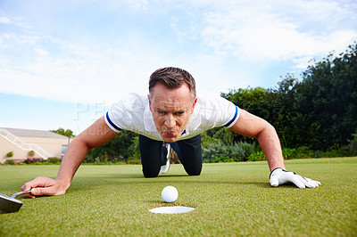 Buy stock photo Mature man, golf ball and cheating on course with blowing for tournament, sportswear and green grass. Male person, sport and blue sky for skill development with game, lying and activity outside