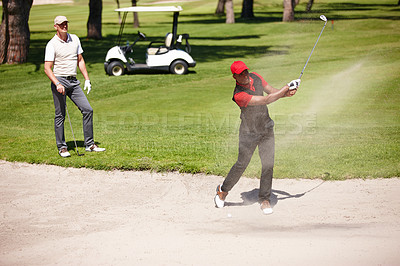 Buy stock photo Men, stroke and golf ball in bunker on summer day for sports, health or exercise outdoor in activewear. People, training and playing game of nine holes on natural turf athlete in sand swinging club