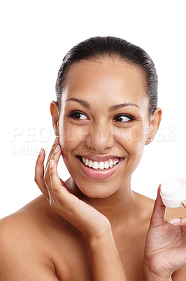 Buy stock photo Cropped shot of a beautiful young woman applying face cream while standing in a studio