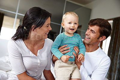 Buy stock photo Family, happiness and parents with child in the home, love and security with parenting, childhood and bonding. Support, trust and care with man, woman and young boy in bedroom, smile and positivity
