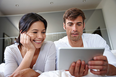 Buy stock photo Cropped shot of a couple spending time together using a digital tablet 
