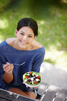 Buy stock photo Cropped shot of an attractive woman sitting in a garden and having a fresh salad 