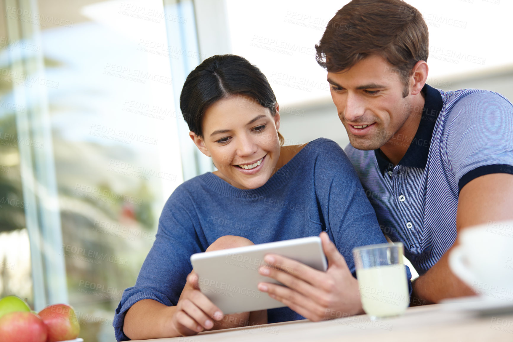 Buy stock photo Cropped shot of an affectionate couple using a digital tablet together