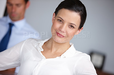 Buy stock photo Cropped portrait of a businesswoman sitting with her colleague in the background