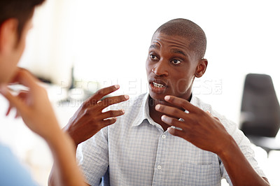 Buy stock photo Shot of two young men having a discussion indoors