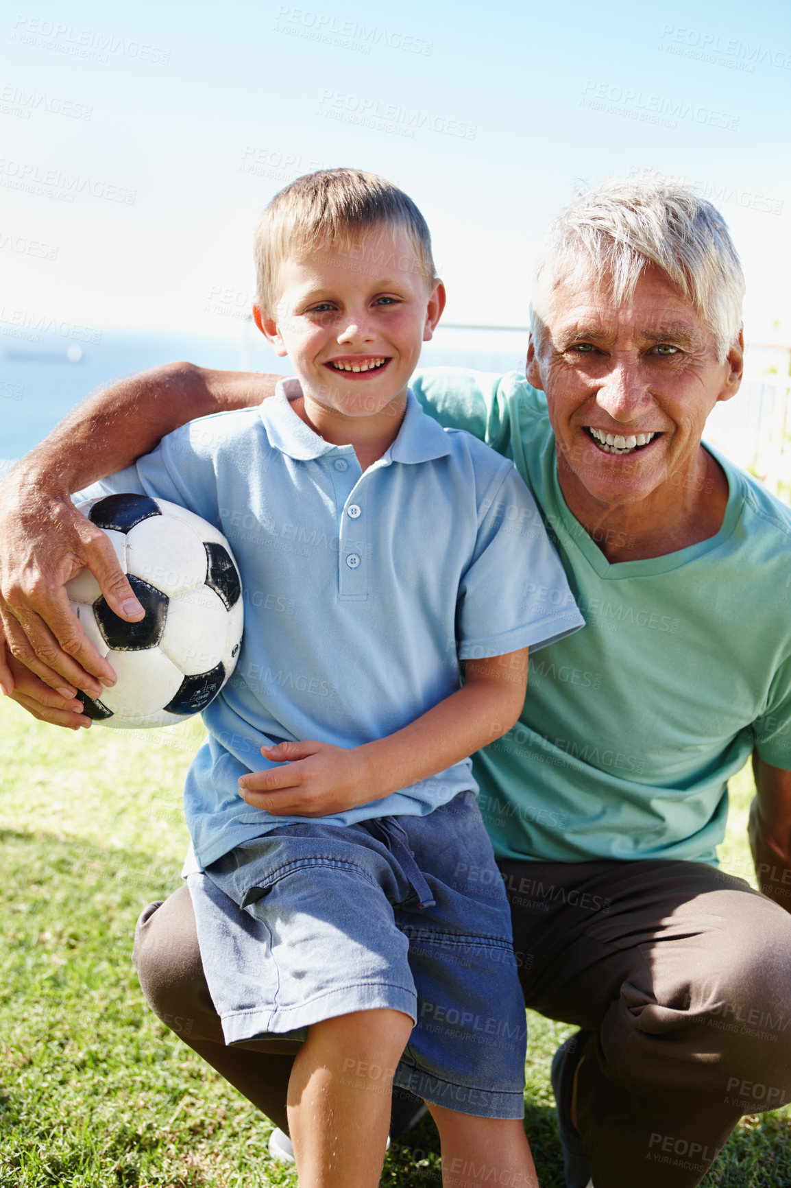 Buy stock photo Senior man, child and football happy in portrait outdoor on field for training, exercise or development. Grandpa, excited and kid smiling on soccer pitch for playing, fitness or bonding in retirement