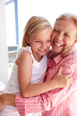 Buy stock photo Grandmother, love and hug of girl in home for vacation, child, and growth of development in holiday. House, senior and old woman with granddaughter, happiness and smile for visit of kid in apartment