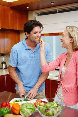 Buy stock photo Happy, man and woman in cheerful, smile and cooking in kitchen at home for dinner, plans and family. Married couple in preparing, food or salad for healthy, eating and nutrition in house with love