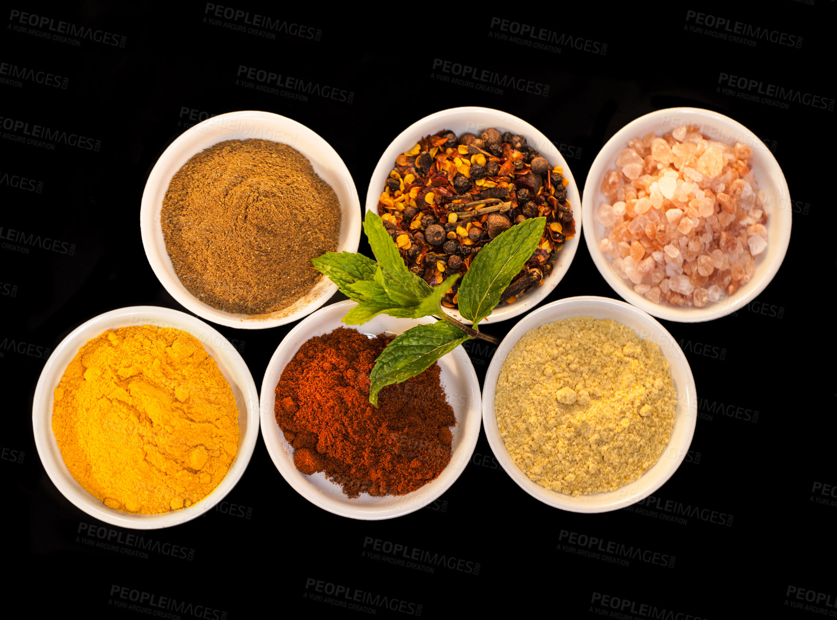 Buy stock photo Shot of an assortment of colorful spices against a black background