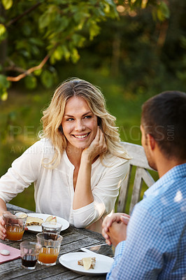 Buy stock photo Smile, couple and eating dinner in garden outdoors at table together. Married, man and woman on romantic honeymoon at house sitting on patio talking, relaxing and caring for healthy relationship
