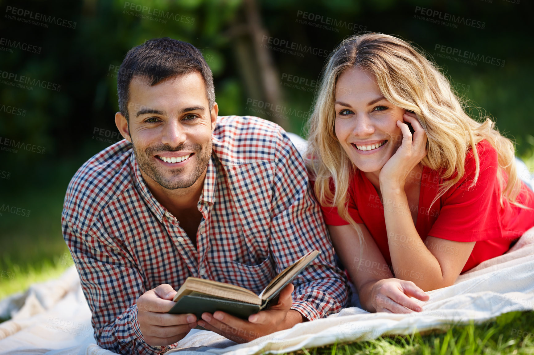 Buy stock photo Portrait, happy couple and nature for reading book in park with green grass, together and picnic blanket. Woman, man and fiction story for hobby in outdoor with happiness, relaxing and romance