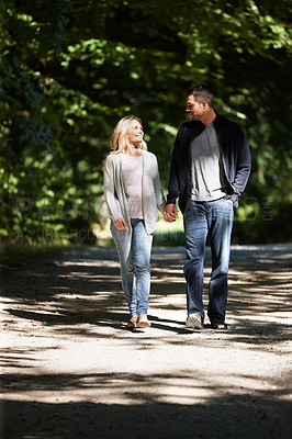 Buy stock photo Couple, hand holding and happy walking in park for love, bonding with care and support in healthy relationship. Man, woman and outdoor for date with romance, trust and commitment for marriage