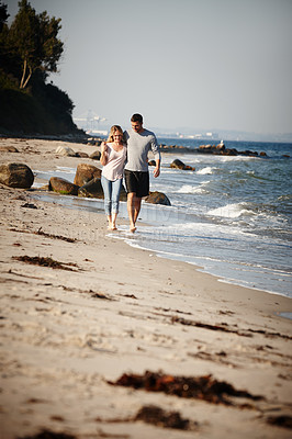 Buy stock photo Couple, walking and hug on shore of beach, peace and travel to nature for holiday. People, embrace and calm on weekend trip or vacation, love and date for relationship or marriage and ocean waves