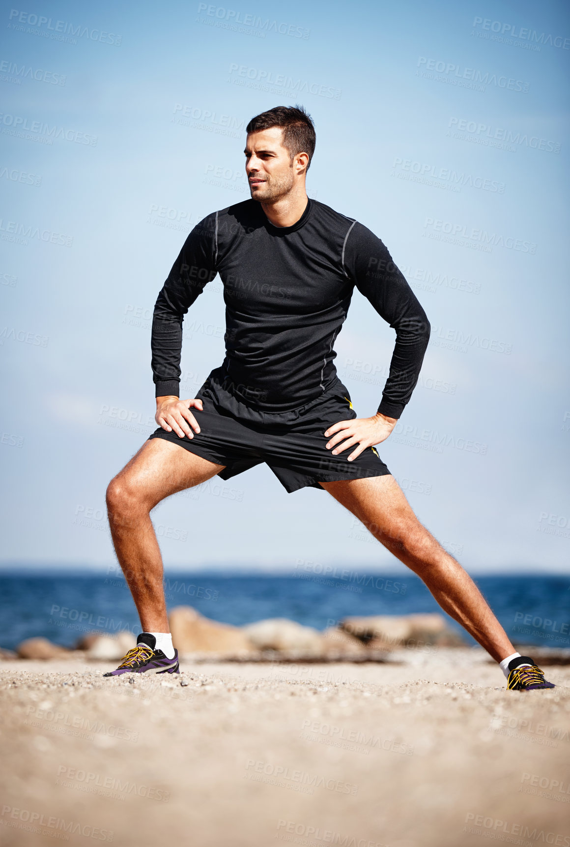 Buy stock photo Man, stretching and ocean on sand with shoes for health, fitness and exercise by beach for peace and calm. Athlete, yoga and sea in morning for wellness, motivation and workout or training by nature