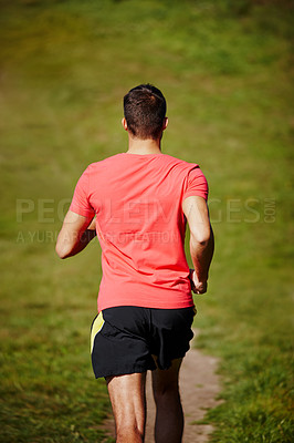 Buy stock photo High angle rearview shot of a young man running on an outdoor trail