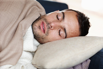 Buy stock photo Man, sleeping and resting with tired, fatigue and burnout on sofa with pillow, blanket and winter. Male person, exhausted and eyes closed at home on weekend with comfort, cozy and relaxed for health