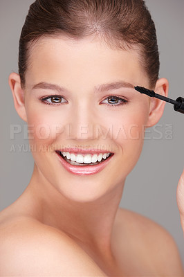 Buy stock photo Makeup, beauty and woman with mascara in studio for wellness, skincare product and cosmetics on grey background. Smile, application and female model with eyelash wand for glamour, makeover and glow