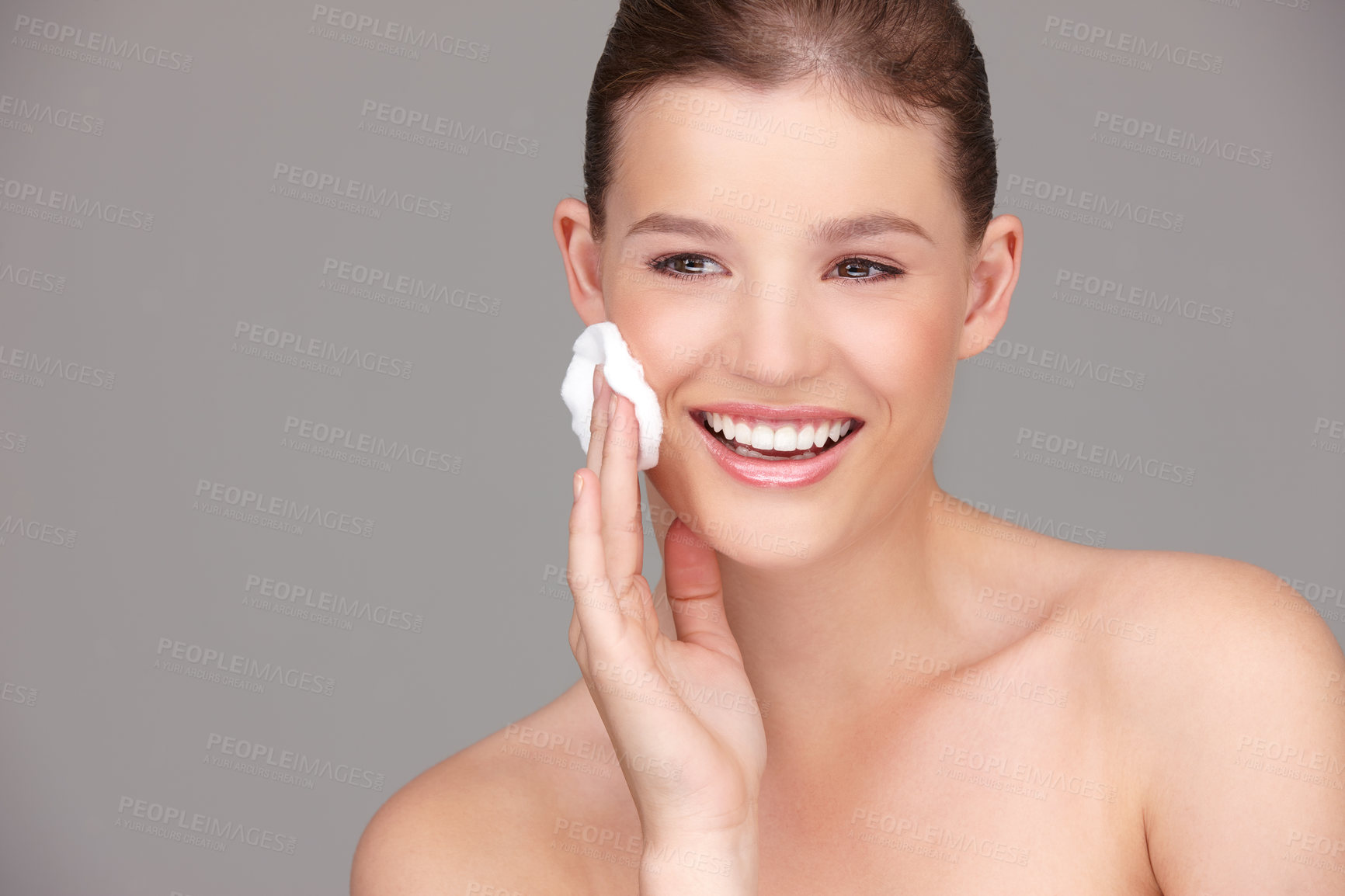 Buy stock photo Skincare, cotton pad and woman in studio with makeup remover for dermatology, wellness or facial skin in gray background. Beauty, hand and happy female model for toner, application and cleansing