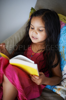 Buy stock photo Shot of a cute little girl reading a book