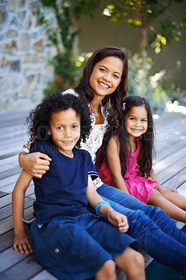 Buy stock photo Shot of a mother relaxing outdoors with her daughter and son