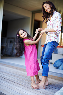 Buy stock photo Shot of a cute little girl dancing on the feet of her mother